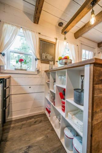 a kitchen with white shelves and a window at Cozy Cabin Little Red Hen 12 min to Magnolia in Waco