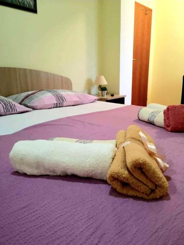a towel is laying on a purple bed at Apartman Roza in Ploče