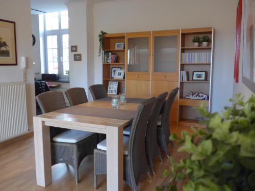 een eetkamer met een houten tafel en stoelen bij BelArté framing shop, spacious apartment with garage in the heart of Ieper in Ieper