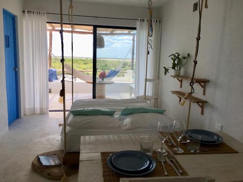 a bedroom with a bed and a table with plates on it at LunArena Barefoot Comfort in El Cuyo