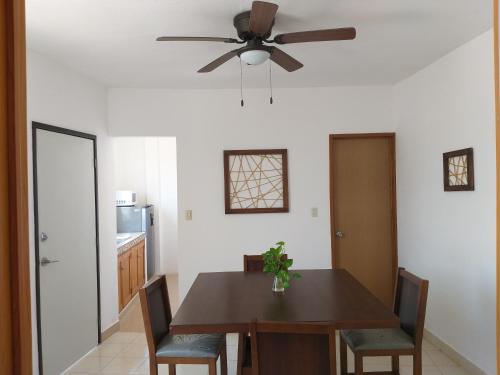 a dining room with a table and a ceiling fan at Depto Las Puertas la Ria #5 in Campeche