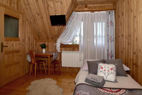 a room with a couch and a table with a window at Na ubocy in Brzegi