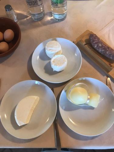 a table with plates of cheese and eggs on it at Cascina Papa Mora in Cellarengo