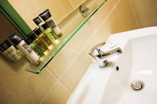 ein Waschbecken im Bad mit einem Glasregal darüber in der Unterkunft New Town Guest House (Adults Only) in Edinburgh