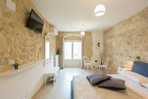 a living room with a couch and a tv on a wall at Evoca in Ragusa