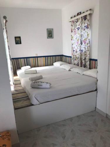 a large white bed in a room with a window at Villa George in Apolakkiá