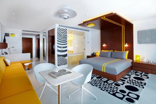a bedroom with a bed and a table and chairs at Chill Hotel Seminyak in Seminyak
