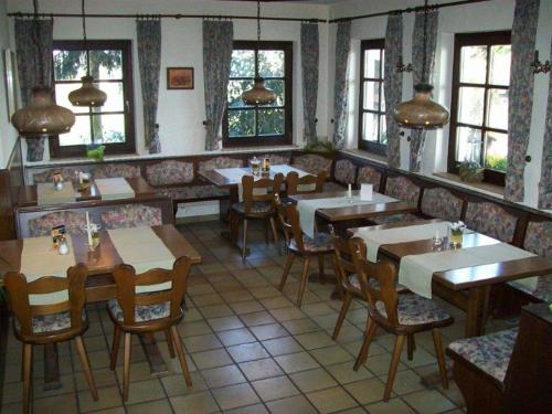 a restaurant with wooden tables and chairs and windows at Gasthaus Hinterländer Schweiz in Gladenbach