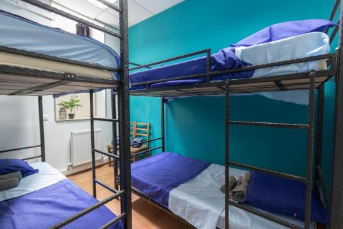 two bunk beds in a room with blue walls at GLOBAL HOSTEL - Freedom Square in Tbilisi City