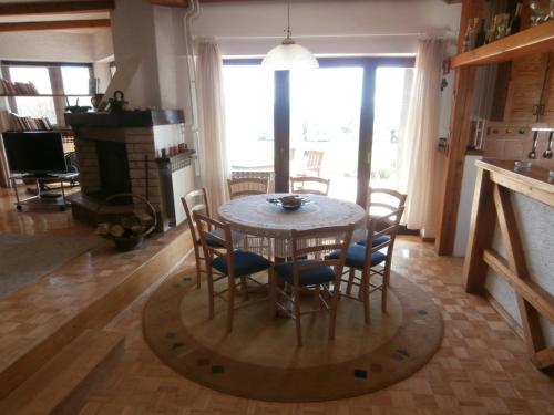a dining room with a table and chairs and a fireplace at Pension Kezele in Graberje Ivanićko