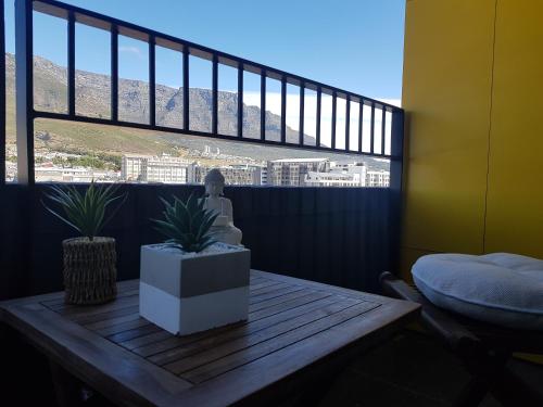 a balcony with a table with two plants on it at Wex 1 Apartments in Cape Town