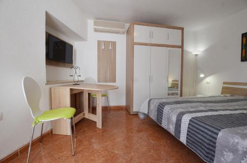 a hotel room with a bed and a desk and a television at Yulia Apartments in Rovinj