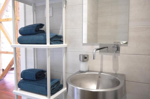 a bathroom with a sink and a mirror and towels at 1881 Historical duplex Suite in Lisbon