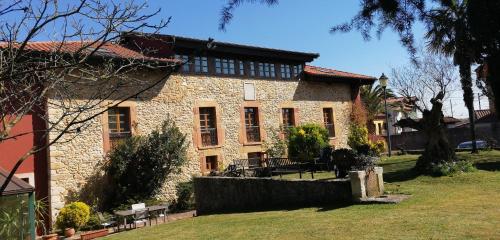 a large stone building with a fence in front of it at Hotel Palacio De La Viñona in Oviedo