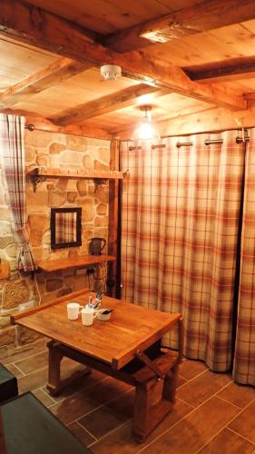 a room with a wooden table in a cabin at Birchwood Guest Lodge in Balmaha