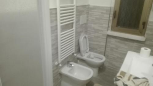 a bathroom with a white toilet and a sink at Residenza villoresi in Cormano