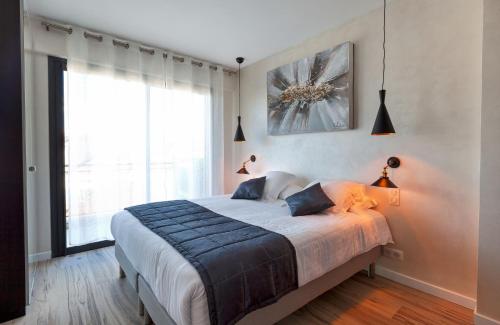 a bedroom with a large bed and a large window at Residence Provencal - Luxurious - 300m Palais - LRA CANNES in Cannes