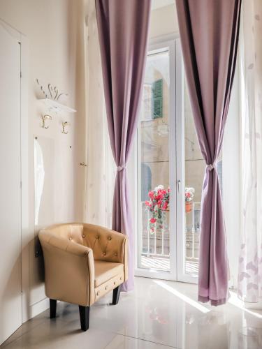 a room with a chair in front of a window at L'Opera Rooms & Suite in La Spezia
