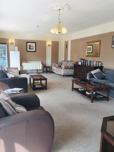 a living room with couches and a table at Seawold Guest House in St. Brelade
