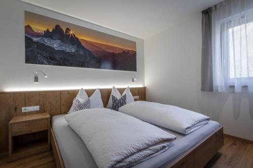 um quarto com uma cama com uma fotografia na parede em Chalet Morin em San Martino in Badia