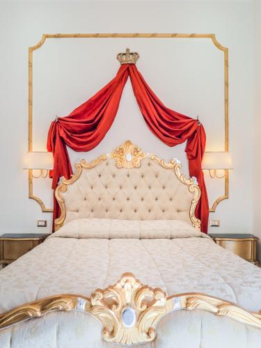 a bedroom with a large bed with a red curtain at L'Opera Rooms & Suite in La Spezia