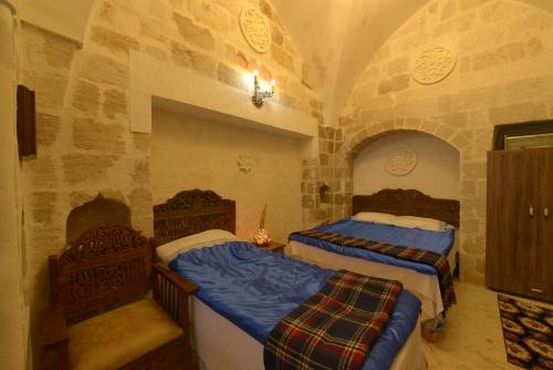 um quarto com duas camas e duas cadeiras em MERDİN BOUTİQUE HOTEL em Mardin