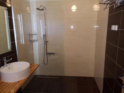 bagno con lavandino bianco e doccia di Panorama Sunset Apartments a Cres