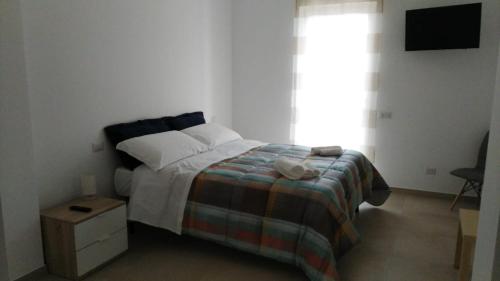 een kleine slaapkamer met een bed en een raam bij Via della Salvia in Matera