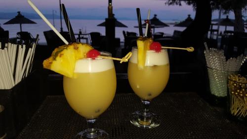 two drinks on a table with fruit on top at Scheria Hotel in Dassia