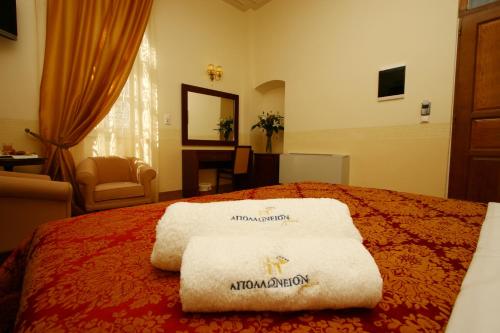 a hotel room with a bed with towels on it at Apollonion Palace in Ermoupoli