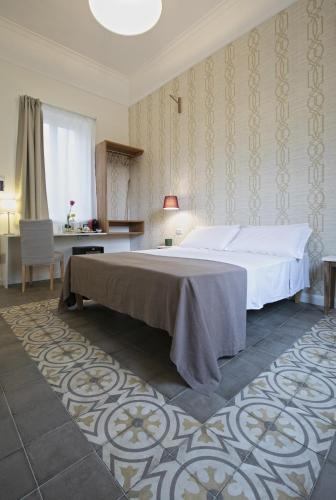 a bedroom with a large bed and a desk at Bed in Spa in Palermo