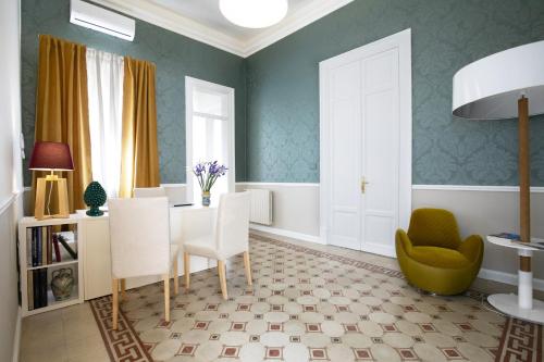 a dining room with green walls and a table and chairs at Bed in Spa in Palermo