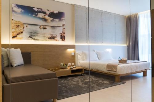 a hotel room with a bed and a couch at Posia Retreat & Spa UNA Esperienze in San Foca