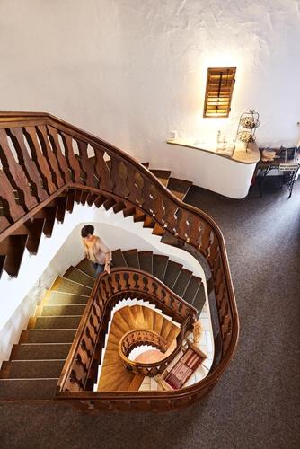 a person walking down a spiral staircase at Hotel Garni Eder in Gmund am Tegernsee