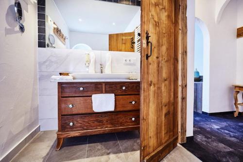 a bathroom with a sink and a wooden door at Hotel Garni Eder in Gmund am Tegernsee