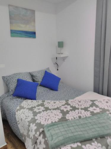 a bedroom with a bed with blue pillows at Além Tejo in Elvas