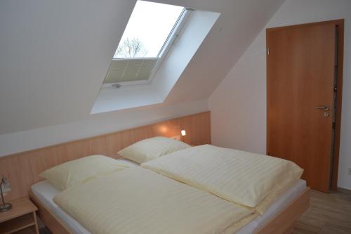 a bedroom with a large bed with a window at Appartement Dachgeschoss in Schlepzig