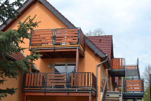 a house with wooden balconies on the side of it at Appartement Dachgeschoss in Schlepzig