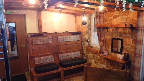 a room with a stone wall with two benches at Birchwood Guest Lodge in Balmaha