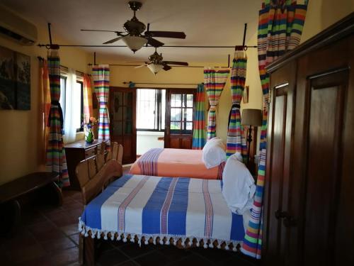 a bedroom with two beds and a ceiling fan at Hotel Casamar Suites in Puerto Escondido