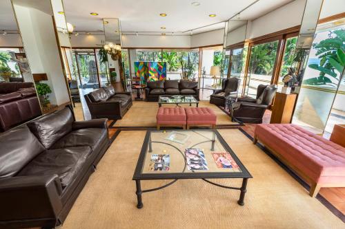 a living room with leather furniture and a table at Hotel del Lago Golf & Art Resort in Punta del Este