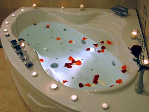 a bath tub covered in confetti with candles in it at Villa Panda at C Links Golf Resort in Mui Ne