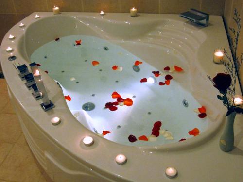 a bath tub covered in confetti with candles in it at Villa Panda at Sea Links Golf Resort in Mui Ne