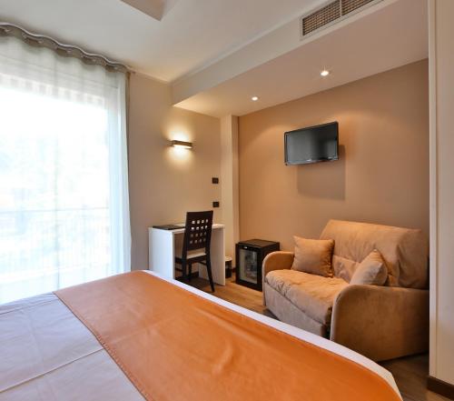 a bedroom with a couch and a tv on the wall at Best Western Regina Elena in Santa Margherita Ligure