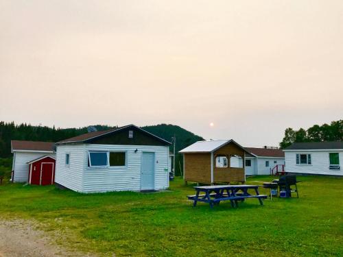 a park with a picnic table and buildings at Bonne Bay Cottages in Bonne Bay Pond
