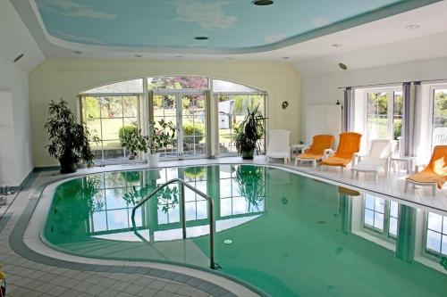 a swimming pool in a house with orange chairs at Apartment in Schwielochsee OT Guhlen 36012 in Guhlen