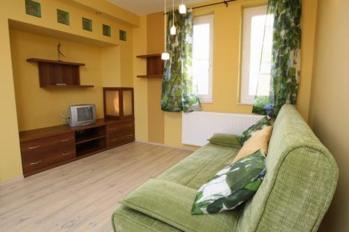 a living room with a couch and a tv at Gasthaus Joó-Wellness Pension in Rábapaty