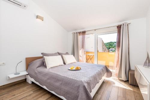 a bedroom with a bed with a plate of oranges on it at Apartment in Vrbnik/Insel Krk 36845 in Vrbnik