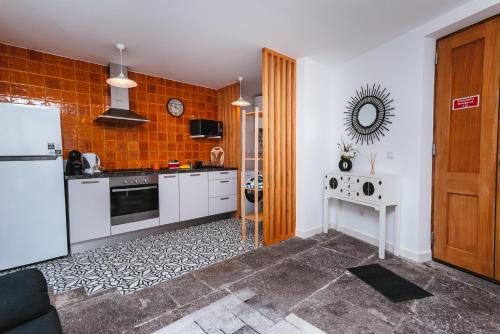 a kitchen with a refrigerator and a table in it at Fortaleza do Pico Apartment in Funchal