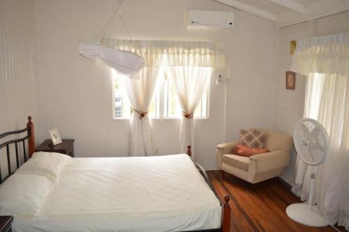 1 dormitorio con 1 cama, 1 silla y 1 ventana en Three Bedroom Holiday Accommodation en Georgetown